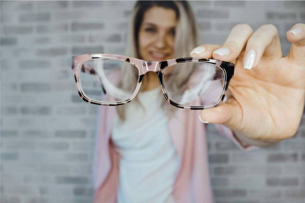 woman holding up her new glasses